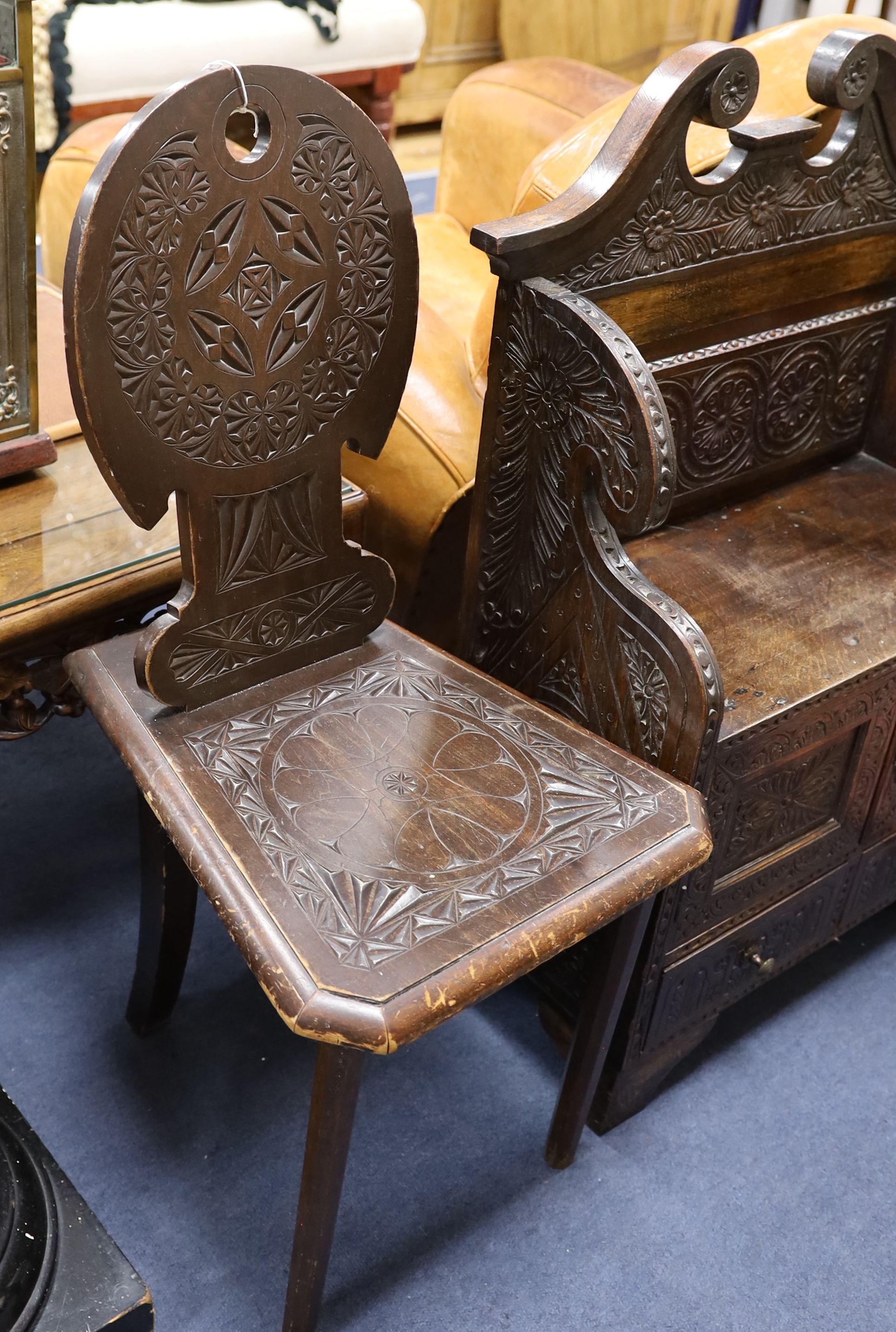 An early 20th century carved oak hall seat, width 64cm, depth 28cm, height 88cm together with two similar hall chairs